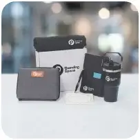 A joining kit with a tech organizer, branded notebook and accessories laid out flat